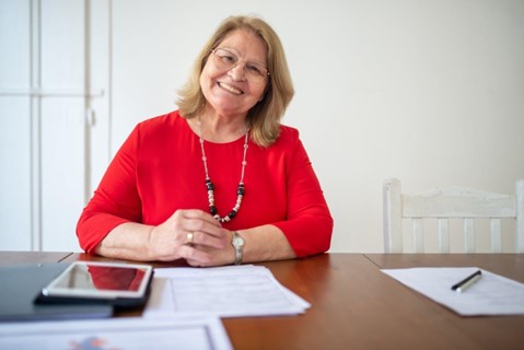 A woman sitting at a desk smiling.